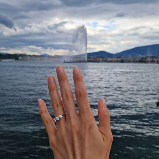 Diamond engagement ring photographed against Lake Geneva with the Jet d’Eau fountain in the background during a proposal trip.