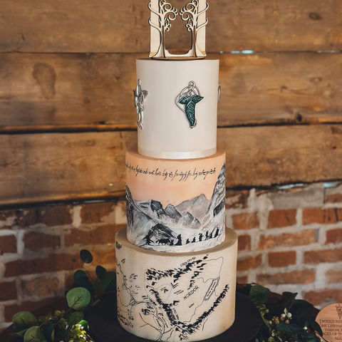 Three-tier fondant wedding cake with Lord of the Rings map, Elvish script, and custom fantasy topper, made for Hannah & Andrew at Wellington Barn.