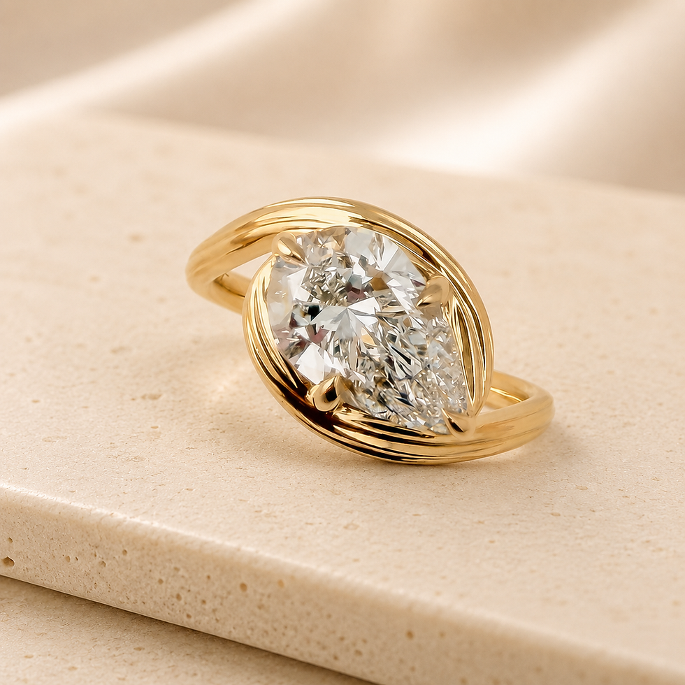 Thea east-west solitaire engagement ring with a pear cut lab grown diamond on a ribbed band in 18ct yellow gold