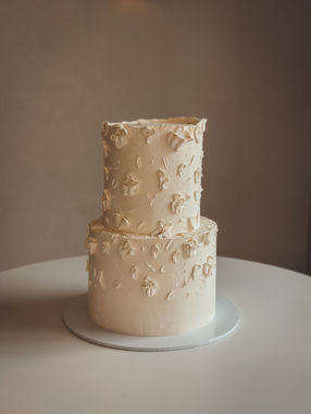 Elegant two-tier ganache wedding cake with sculpted texture, surrounded by candles and white roses at The Pear Tree. Display by Etiquette Event Hire, photo by Jody Sutton Photography.