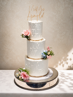 Elegant three-tier textured buttercream wedding cake with blush pink and blue florals at Blunsdon House Hotel in Wiltshire.