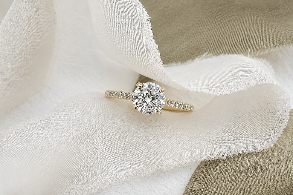 Round brilliant diamond solitaire engagement ring with pavé band on soft neutral fabric background