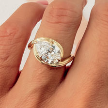 Thea horizontal pear-cut diamond ring worn on a hand.