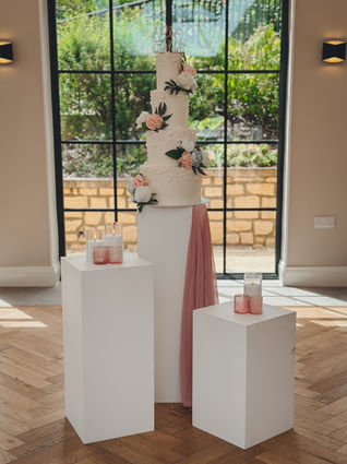 Four-tier ivory wedding cake with pearl detailing and blush florals, styled by Niche Events for Kiara & Jack’s wedding at The Pear Tree.