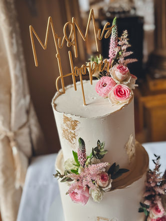 Two-tier buttercream wedding cake with gold leaf and blush fresh florals at Orchardleigh House
