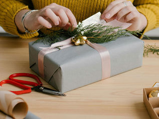 Preparing a wrapped gift with care for a child during YANA’s Christmas Express program.