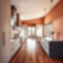 Modern kitchen remodel with warm terracotta and earthy tones, featuring sleek wood floors,