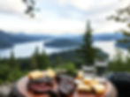 a peaceful nature back drop, a table with choice steak and cheeses on it with water.jpg