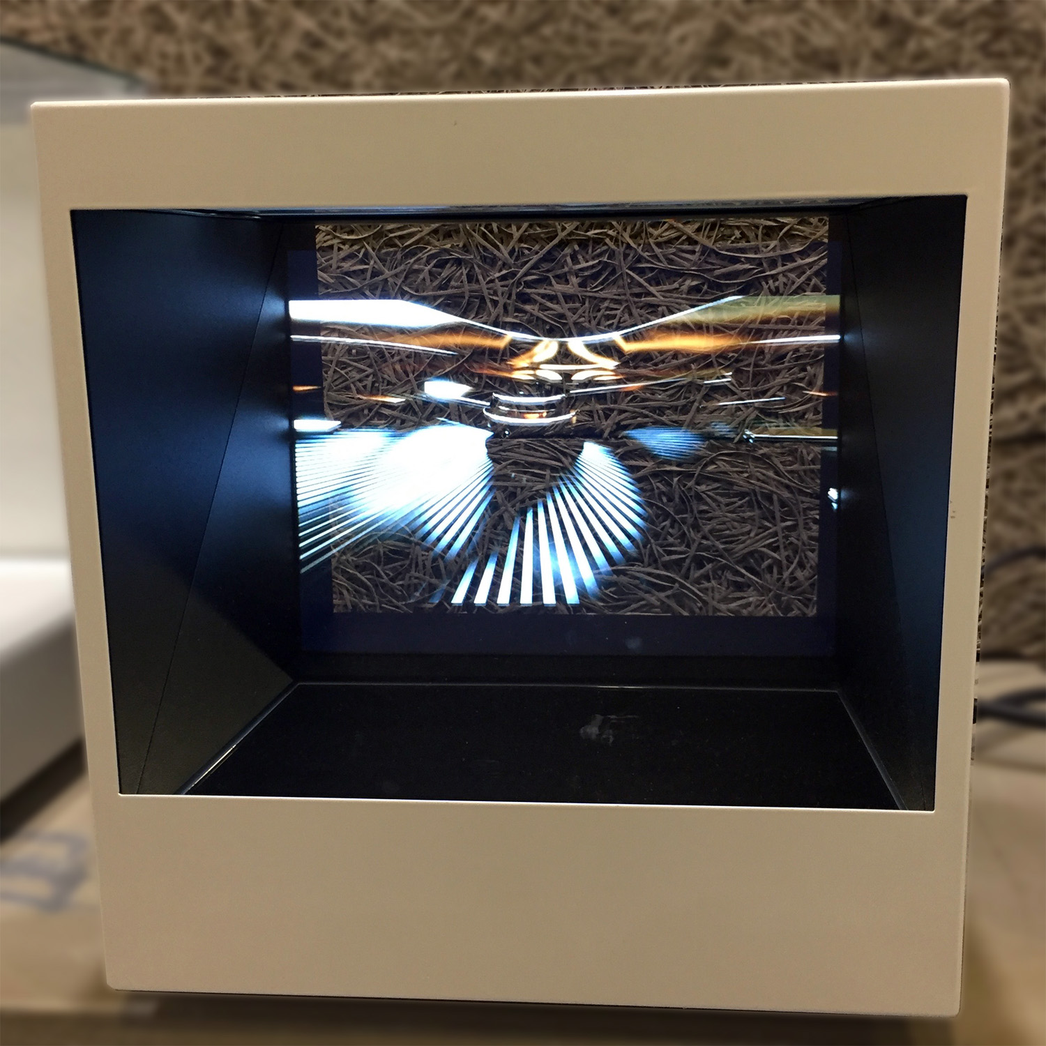 Vitrine holographique POP3 combinant produit physique (max 28cm) et hologramme vidéo avec enceintes intégrées.