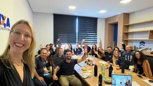 uma sala cheia de pessoas acenando e sorrindo