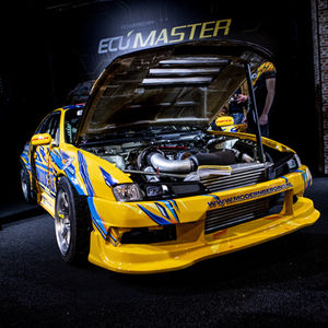 Yellow race car with open hood on display.