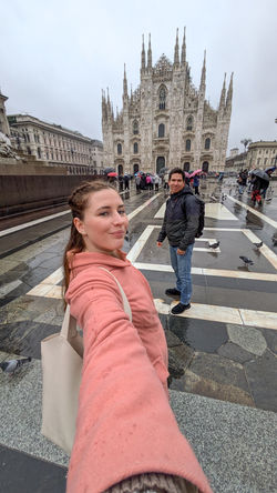 una pareja tomándose un selfie en la plaza de Milán