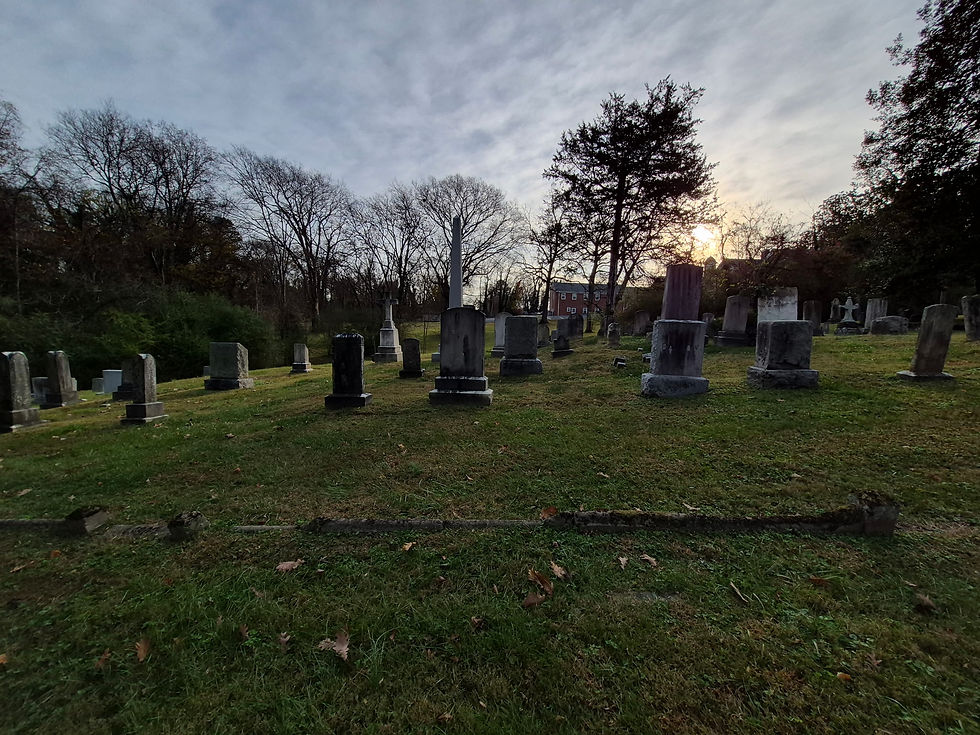 Wide-angle view of a quiet cemetery with engraved granite monuments
