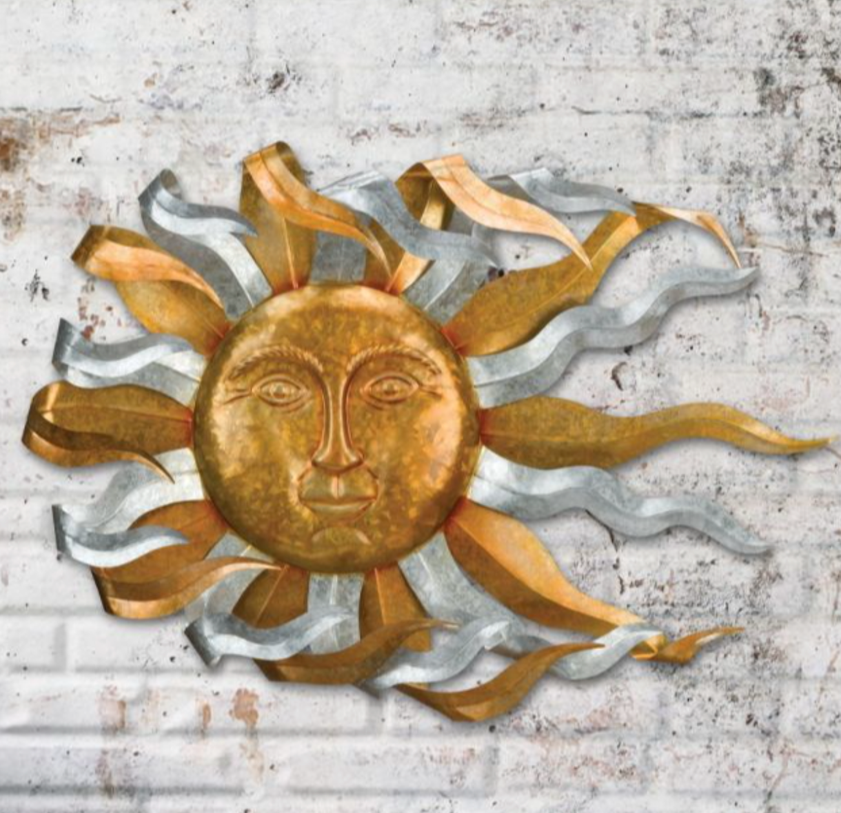 Bronze and silver colored sun with face and curled sun rays on brick wall