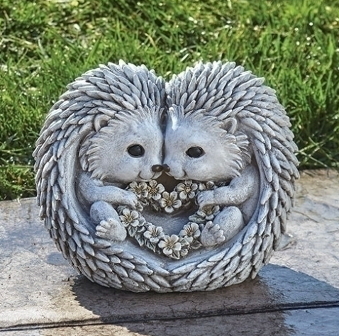 Two cuddling hedgehogs shaped like a heart holding a flower wreath also shaped like heart