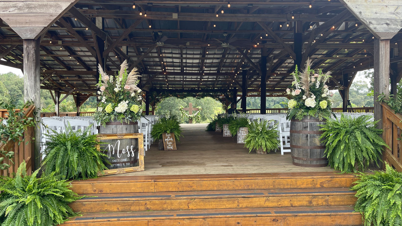 The Wedding Barn at L'Horne venue in middle Georgia featuring our pole barn ceremony site decorated with ferns