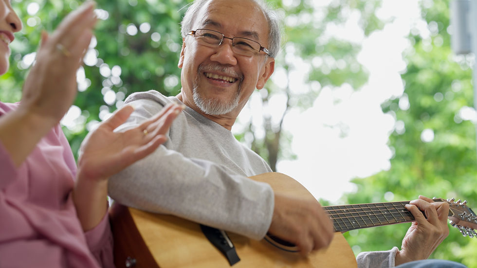 senior asian man playing guitar outside