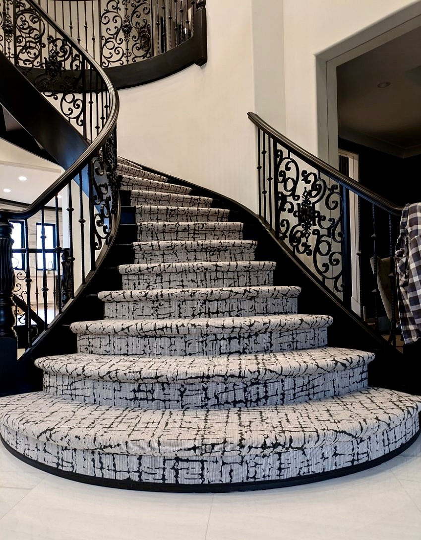 Elegant curved staircase with patterned carpet