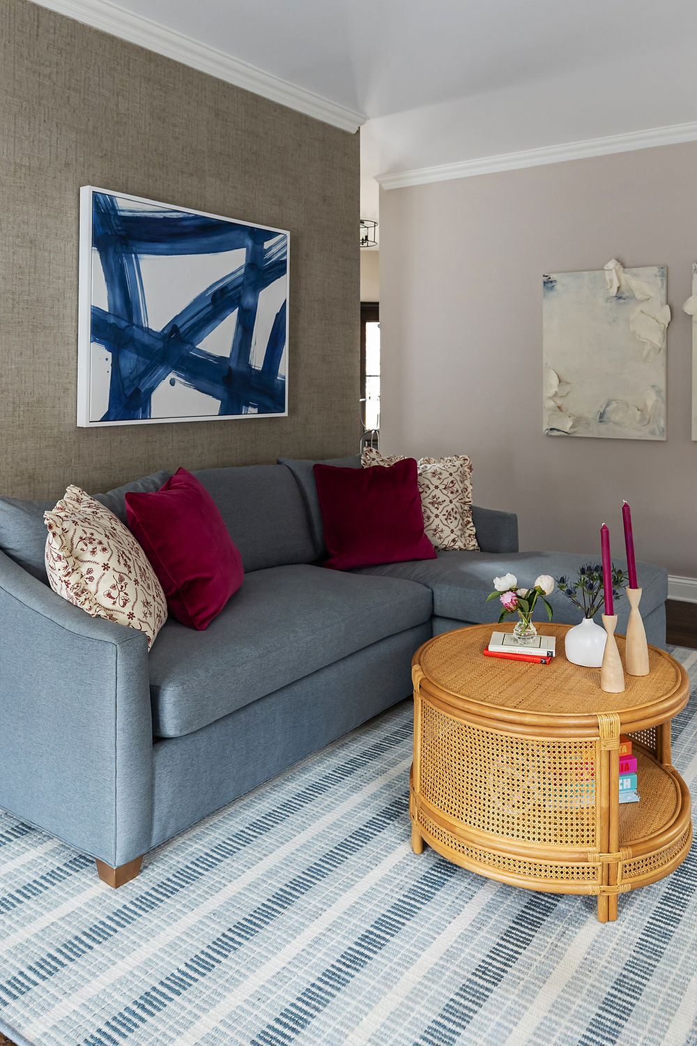 Blue sofa, striped rug, round coffee table, abstract art