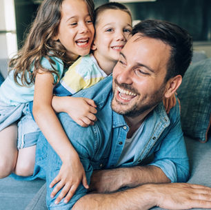 Dad laughing and playing with his kids, showing everyday moments of connection that prove he’s doing well as a parent.