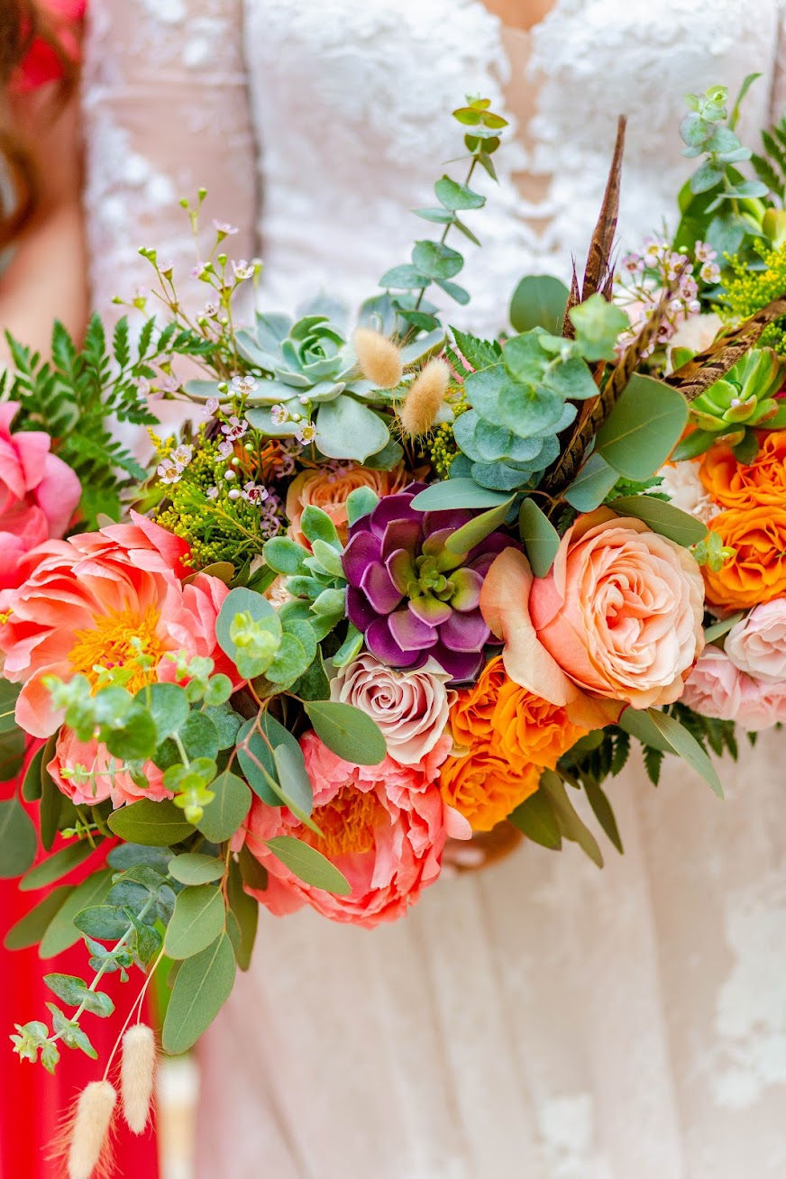 Close-up on a bright colored bridal bouquet with peonies and succulents