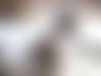 A hand holds a pen filling out planning paperwork on a desk, with a grey cardian on. Papers and a coffee mug sit in the background.