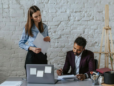 Two people looking over paperwork together.