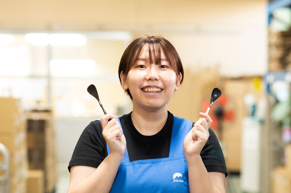 ARASのデザートスプーンを両手に持ち、笑顔を向けるTさん
