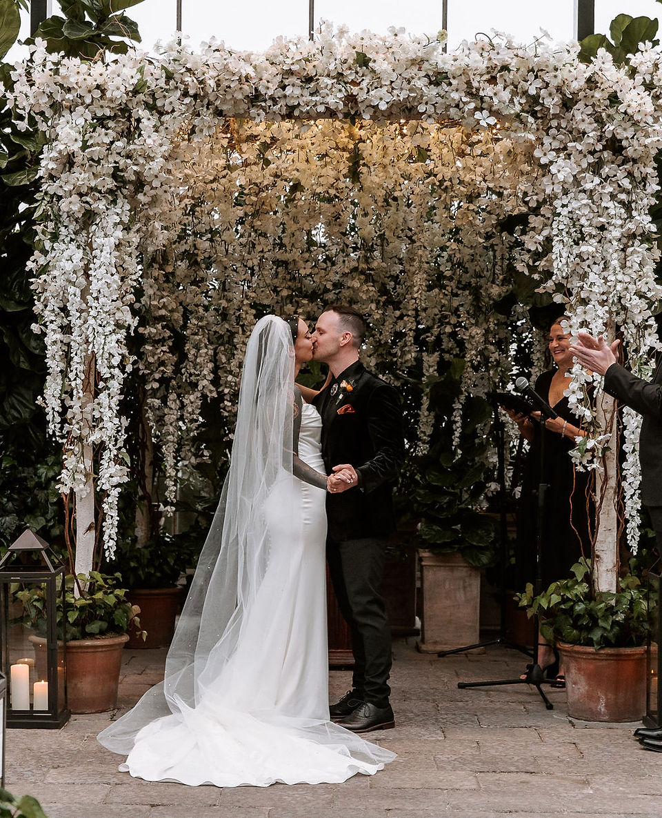 Bride and groom sharing their first kiss as husband and wife at their ceremony.
