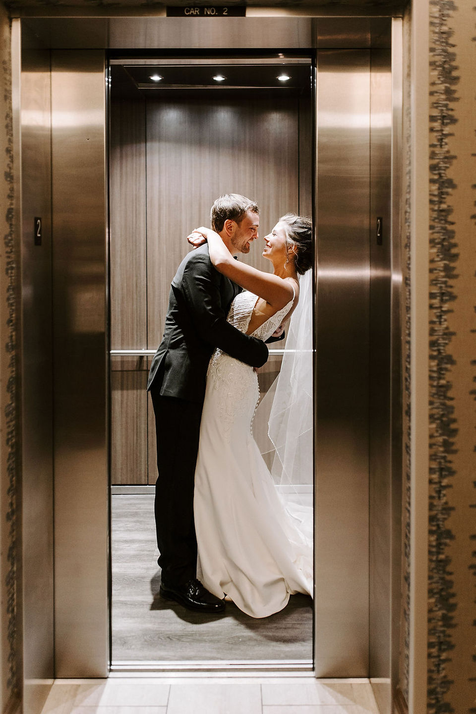 Bride and groom elevator wedding photos at the Embassy Suites hotel in Grand Rapids, Michigan.