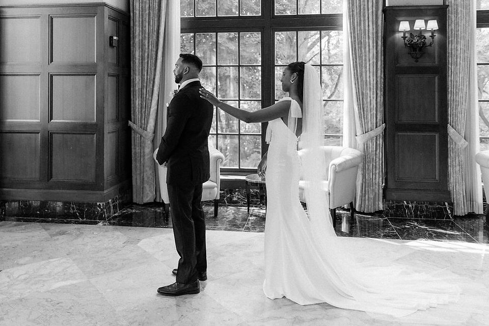 Bride touching the groom's shoulder for their first look.
