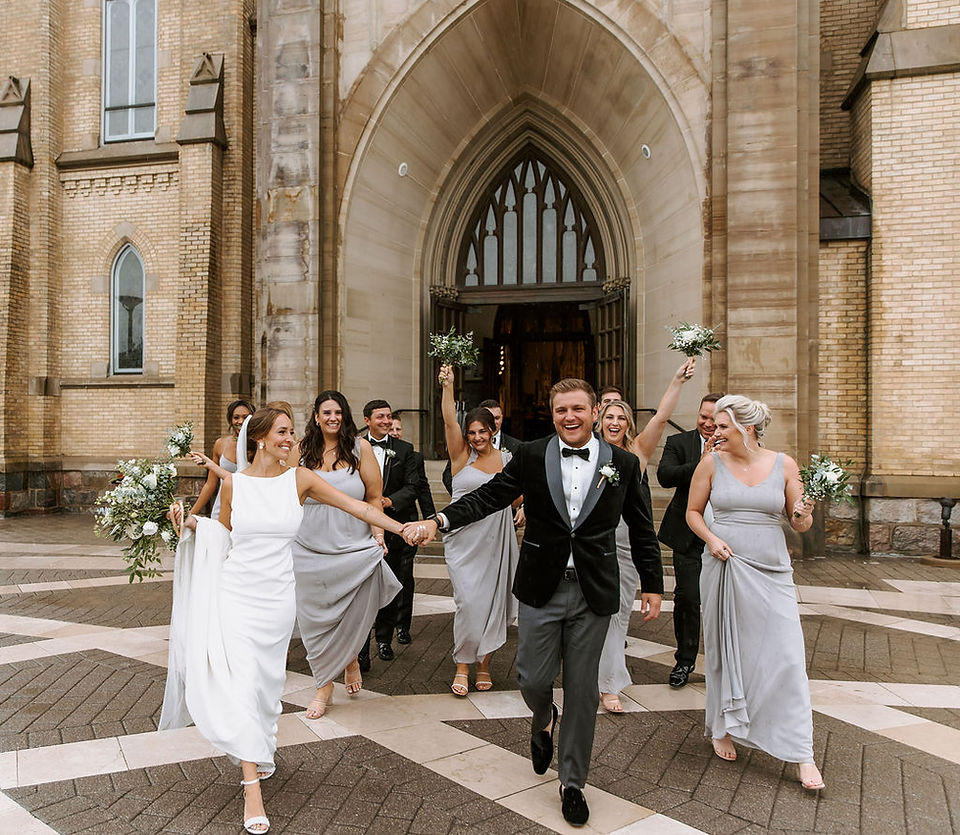 Bridal party celebrating after wedding ceremony at The St. Andrew catholic church in Grand Rapids, Michigan.