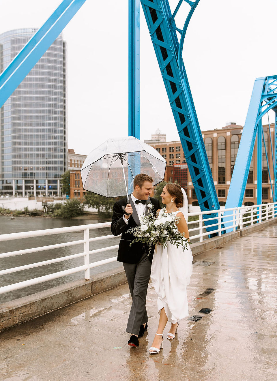 Bride and groom portrait with clear umbrella at The Blue Bridge in Grand Rapids, MI.