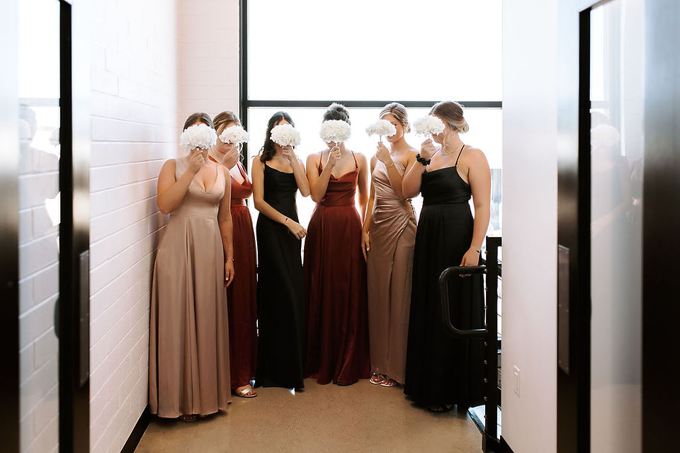 Bridesmaid first look holding their bouquets in front of their face. 