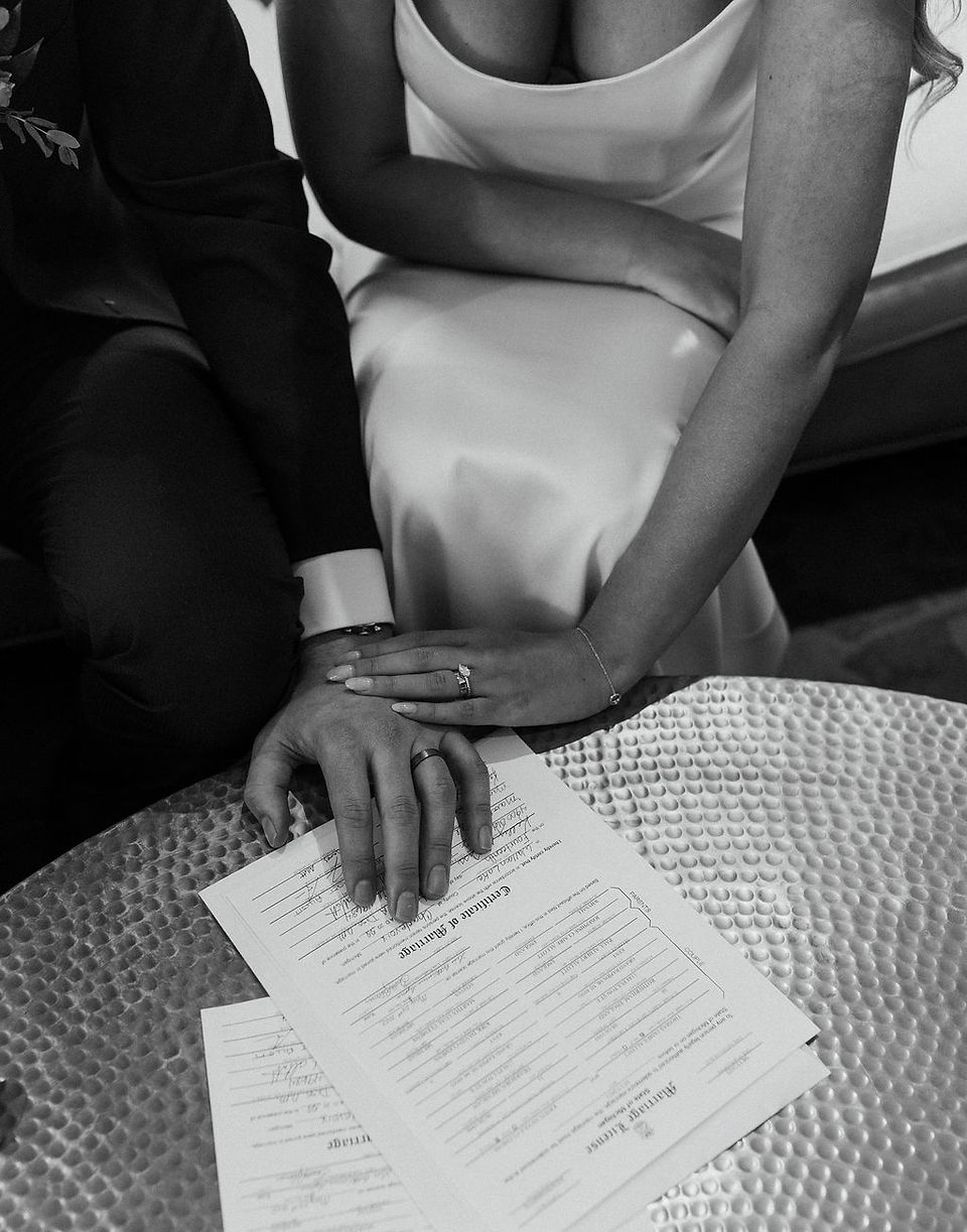 Bride and groom signing their marriage license.