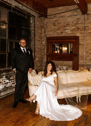 Bride and groom sitting on a vintage couch at Salvage One in Chicago.