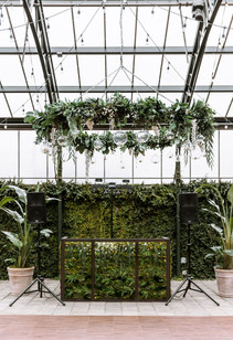 Wedding reception DJ setup against a greenery background at the Planterra Conservatory.