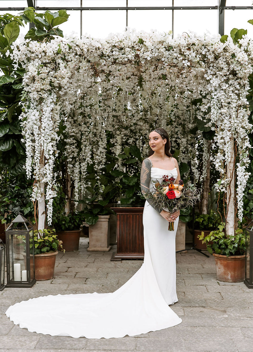 Bride standing in front of a draping floral background.