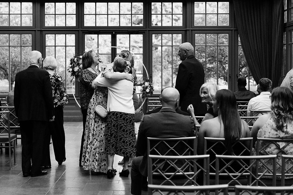 Guests arriving to the wedding ceremony and embracing.
