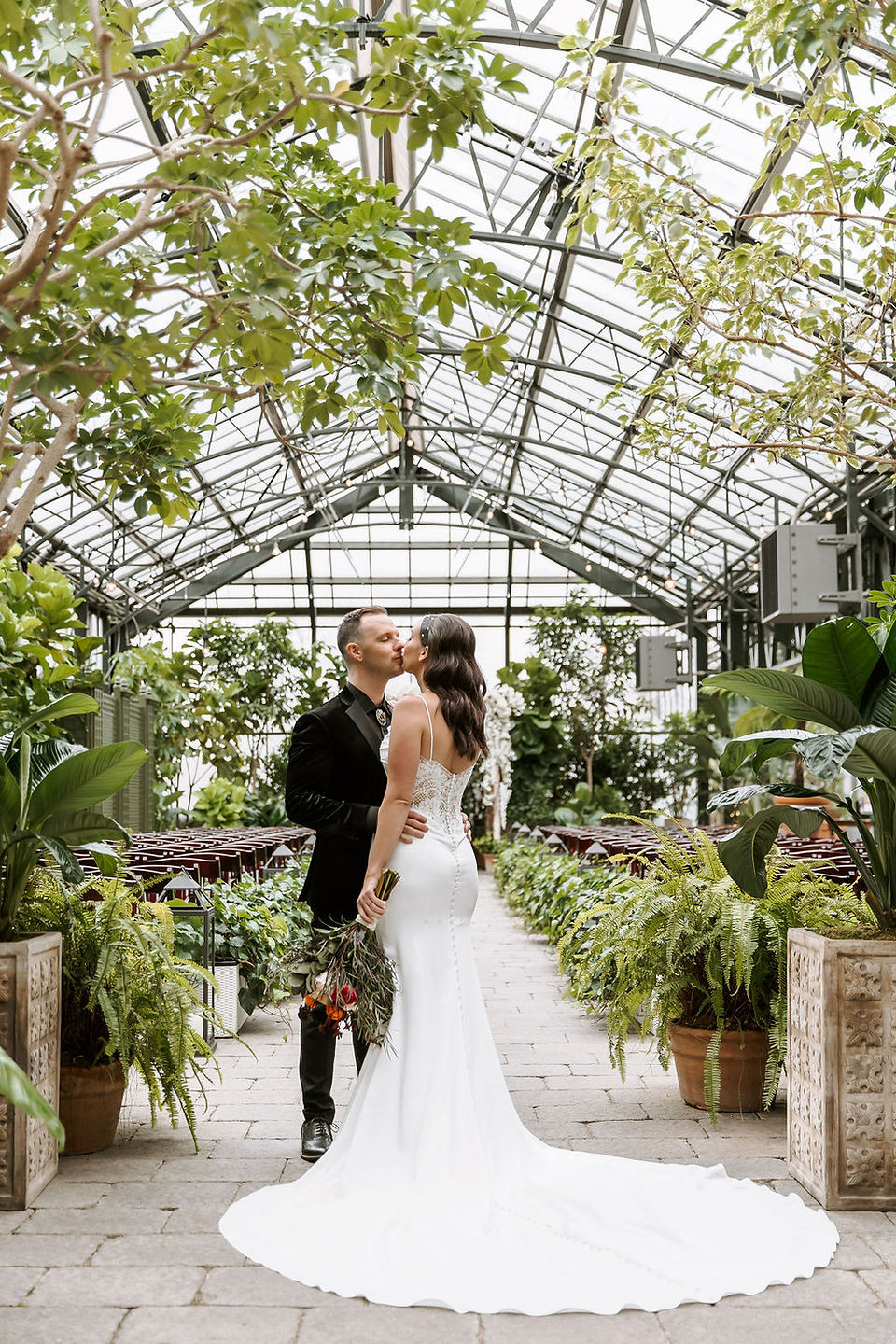 Lovely couple photographed in their wedding attire at Planterra Conservatory, one of the most enchanting glass venues in Michigan.