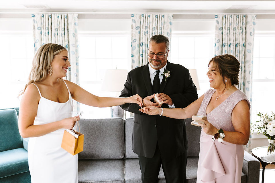 Bride giving wedding gifts to her parents in the bridal suite of Hotel Walloon.