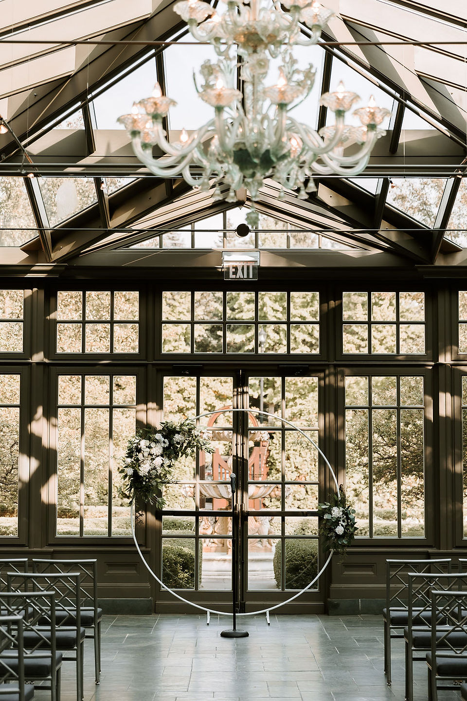 Romantic circle wedding arch with flowers and greenery at the Royal Park Hotel Belgium Glass Conservatory.