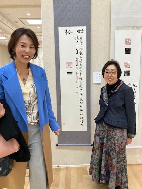 “Ginsho standing in front of her artwork