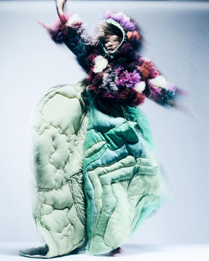 A model wearing a purple and green tulle and pleated dress. Thomas Alexander, 2025 MA Costume Design for Performance, London College of Fashion, UAL. Photograph by Sam Gallagher