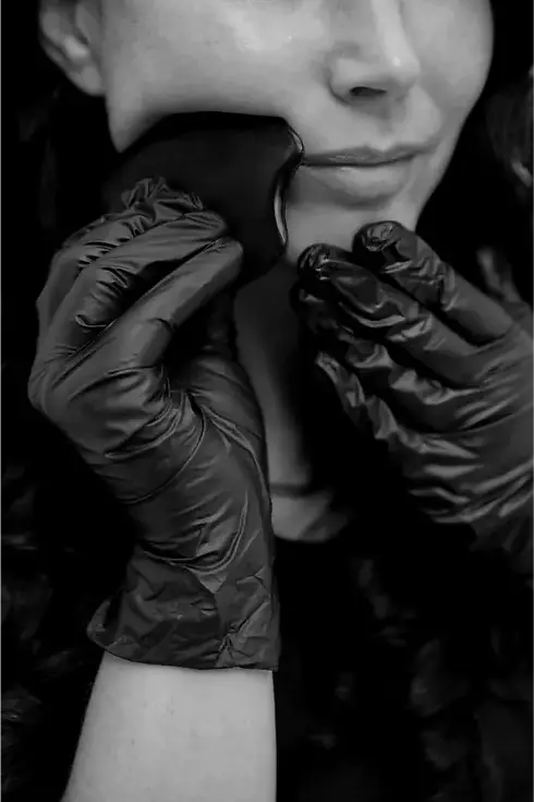 Manuelle Gua-Sha-Technik mit schwarzem Stein – Face Lifting Massage in Graz zur Aktivierung der Gesichtsmuskulatur und Förderung der Durchblutung