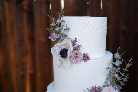 Florale Hochzeitstorte mit lila Dekoration im Boho Stil von der Konditorin Alexandra Pürschl aus Graz.