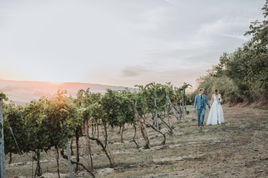 Hochzeitspaar bei Sonnenuntergang in den Weinbergen.