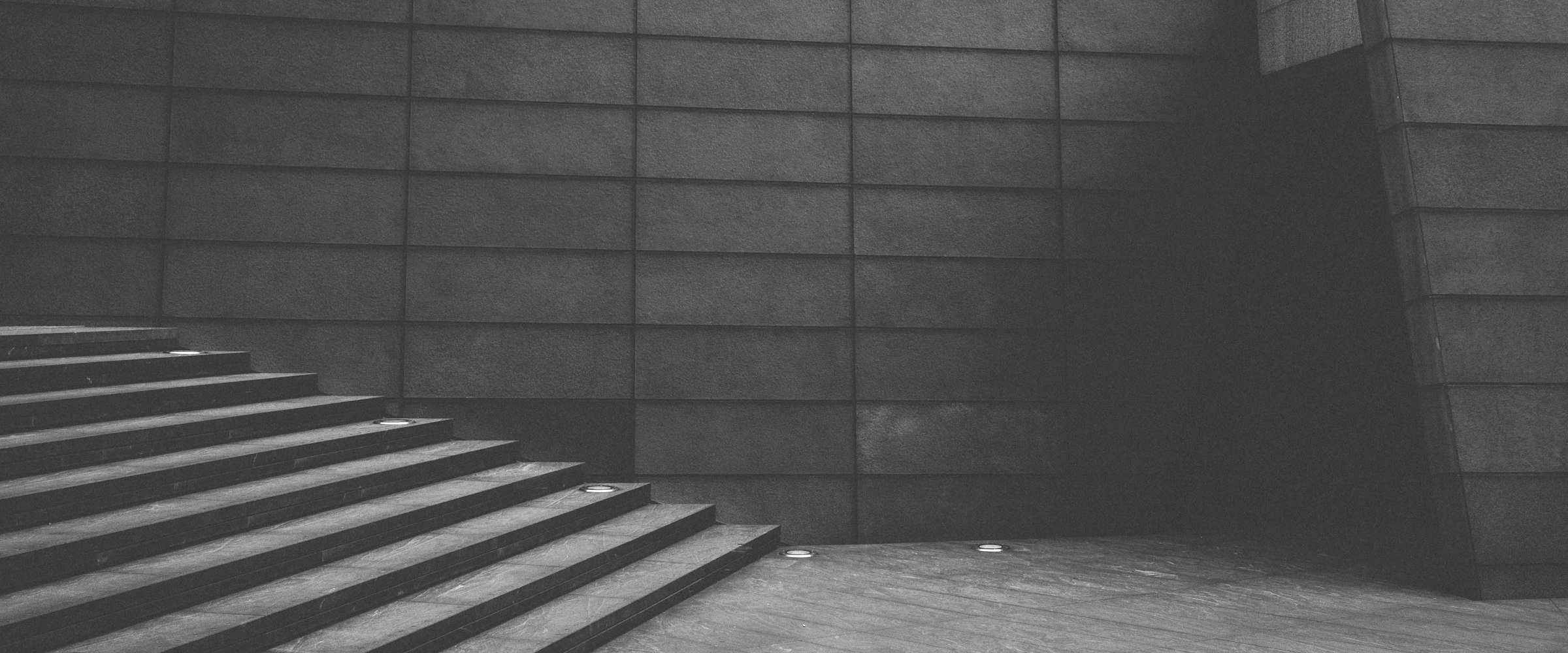 A stone stairway beside a concrete wall.