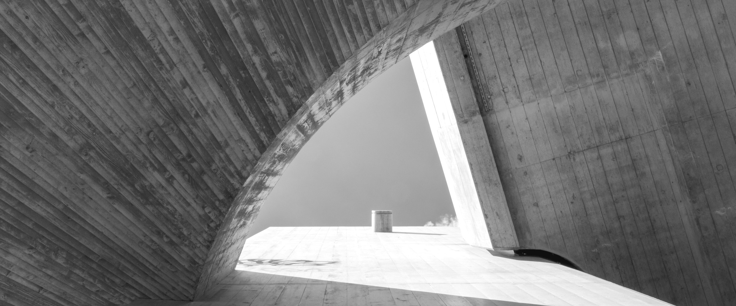 A curved concrete opening onto a quiet courtyard.
