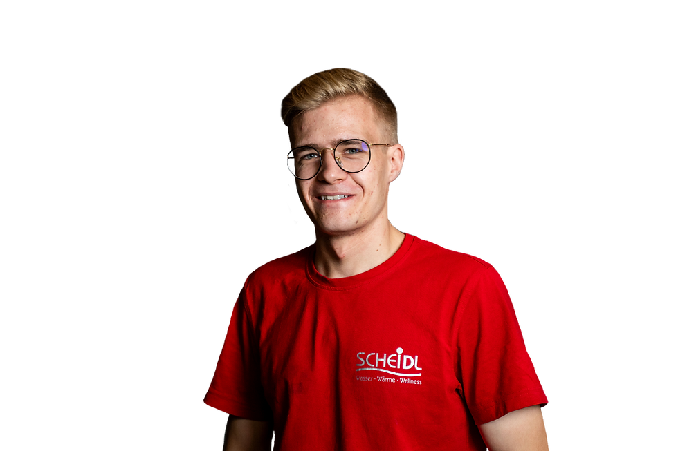 Lächelnde Person steht vor weißem Hintergrund. Er hat ein rotes T-Shirt mit dem Firmenlogo an. Er hat kurz geschnittenes blondes Haar, an den Seiten rasiert und oben länger zur Seite gekämmt, ist glatt rasiert. Er trägt eine runde große Brille.